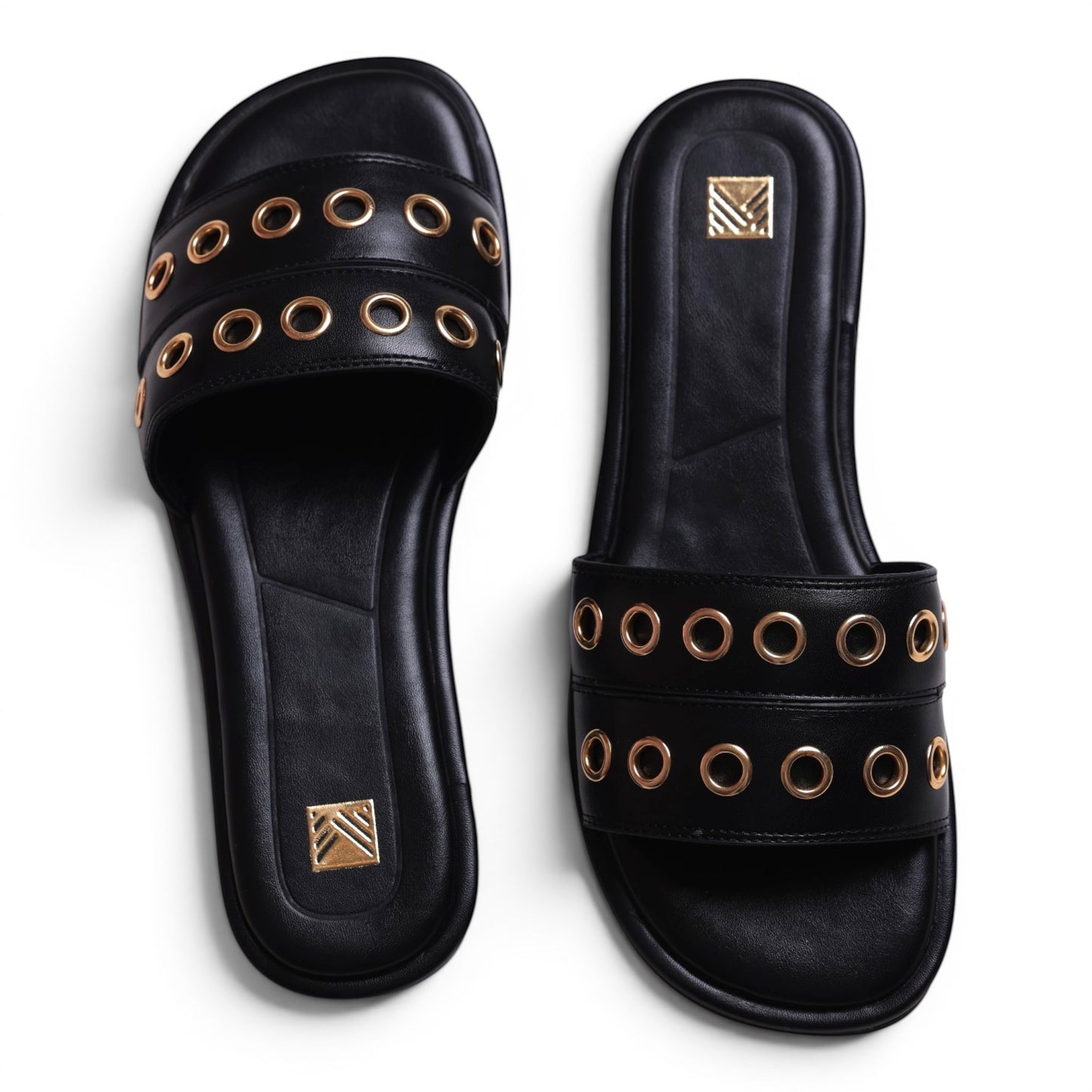 Moda Ug black leather slide sandals with gold grommet details and a square toe.
