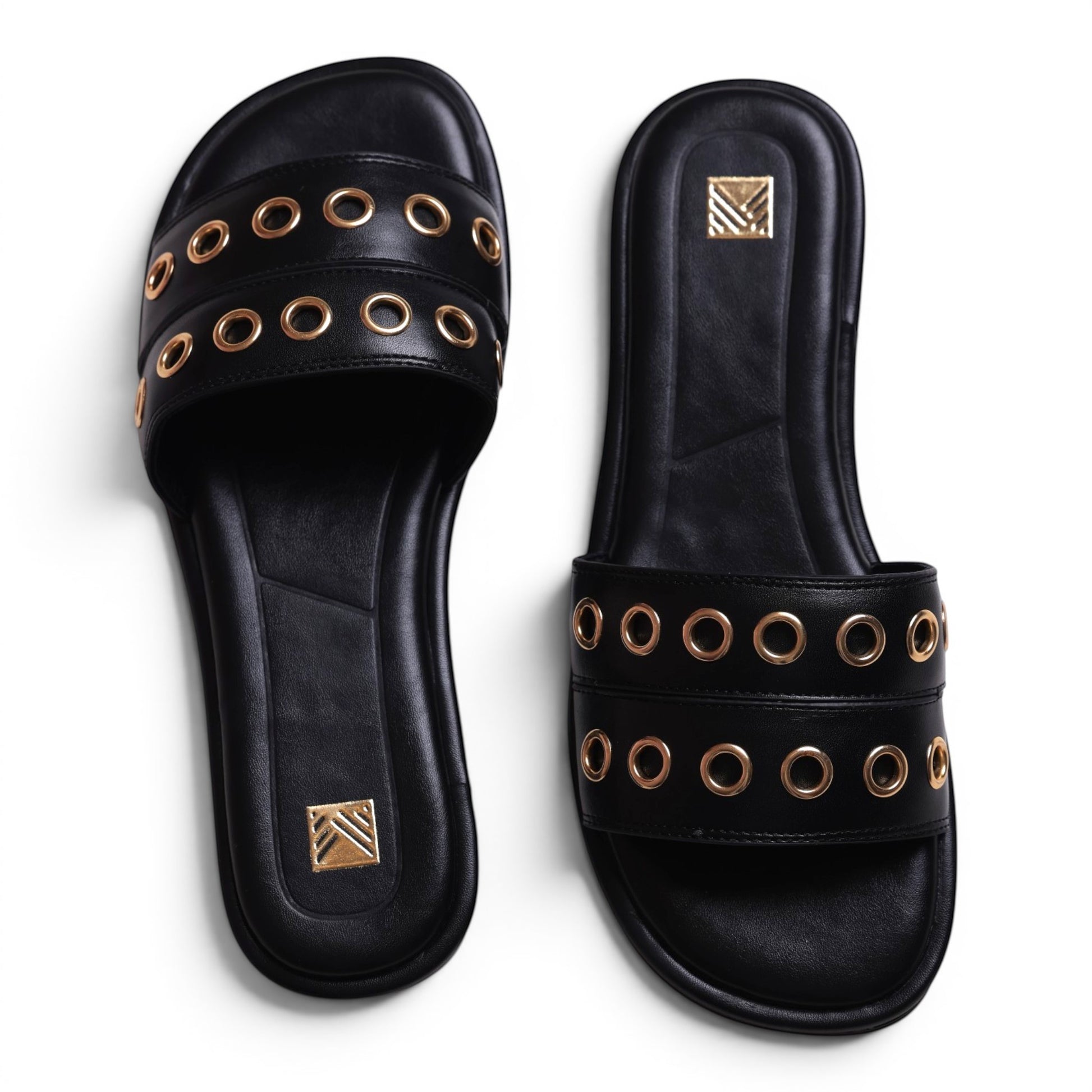 Moda Ug black leather slide sandals with gold grommet details and a square toe.