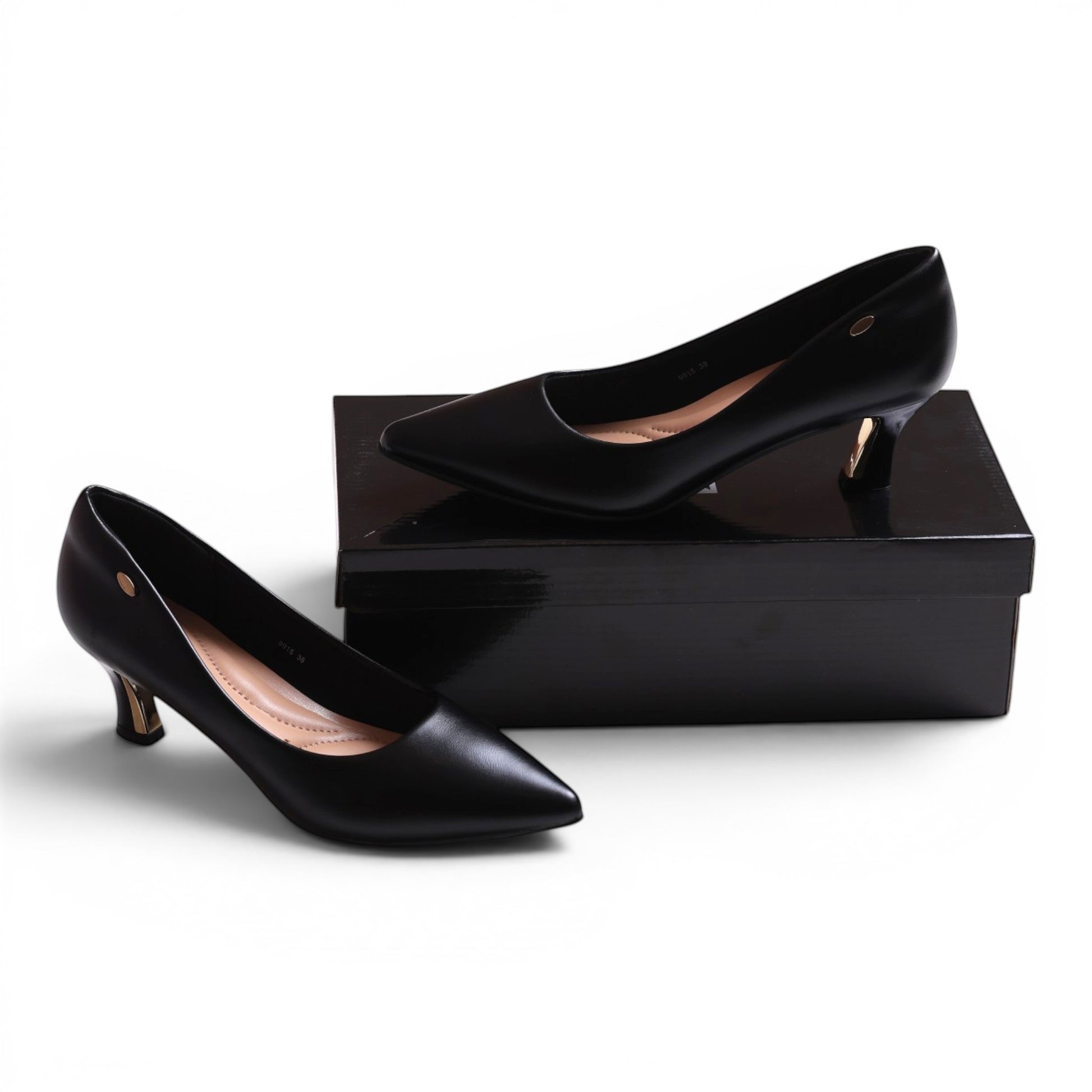 Moda Ug black leather pointed-toe kitten heel pumps with gold accent heel.