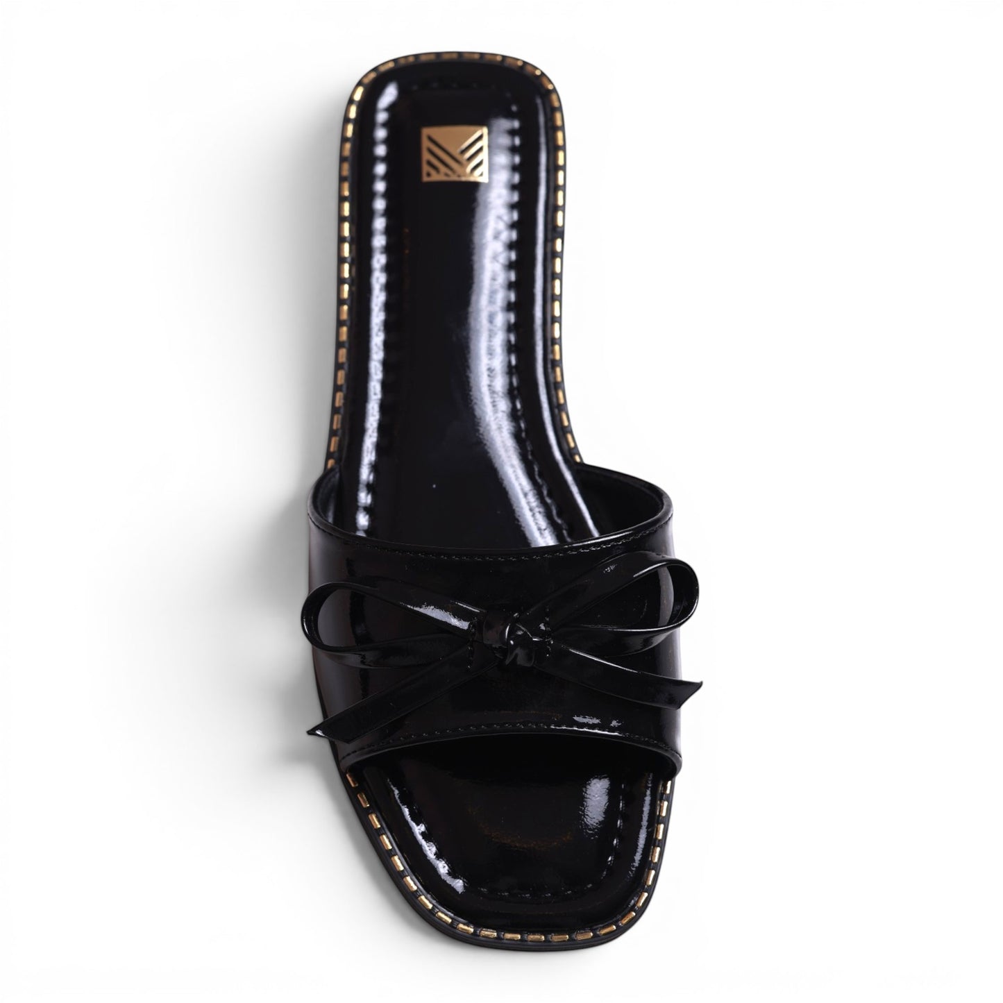 Moda Ug black patent leather slide sandals with bow detail and gold trim. Square toe.