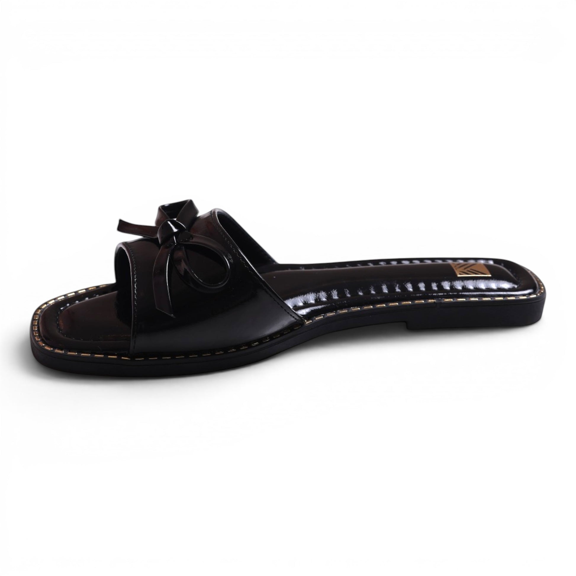 Moda Ug black patent leather slide sandals with bow detail and square toe.