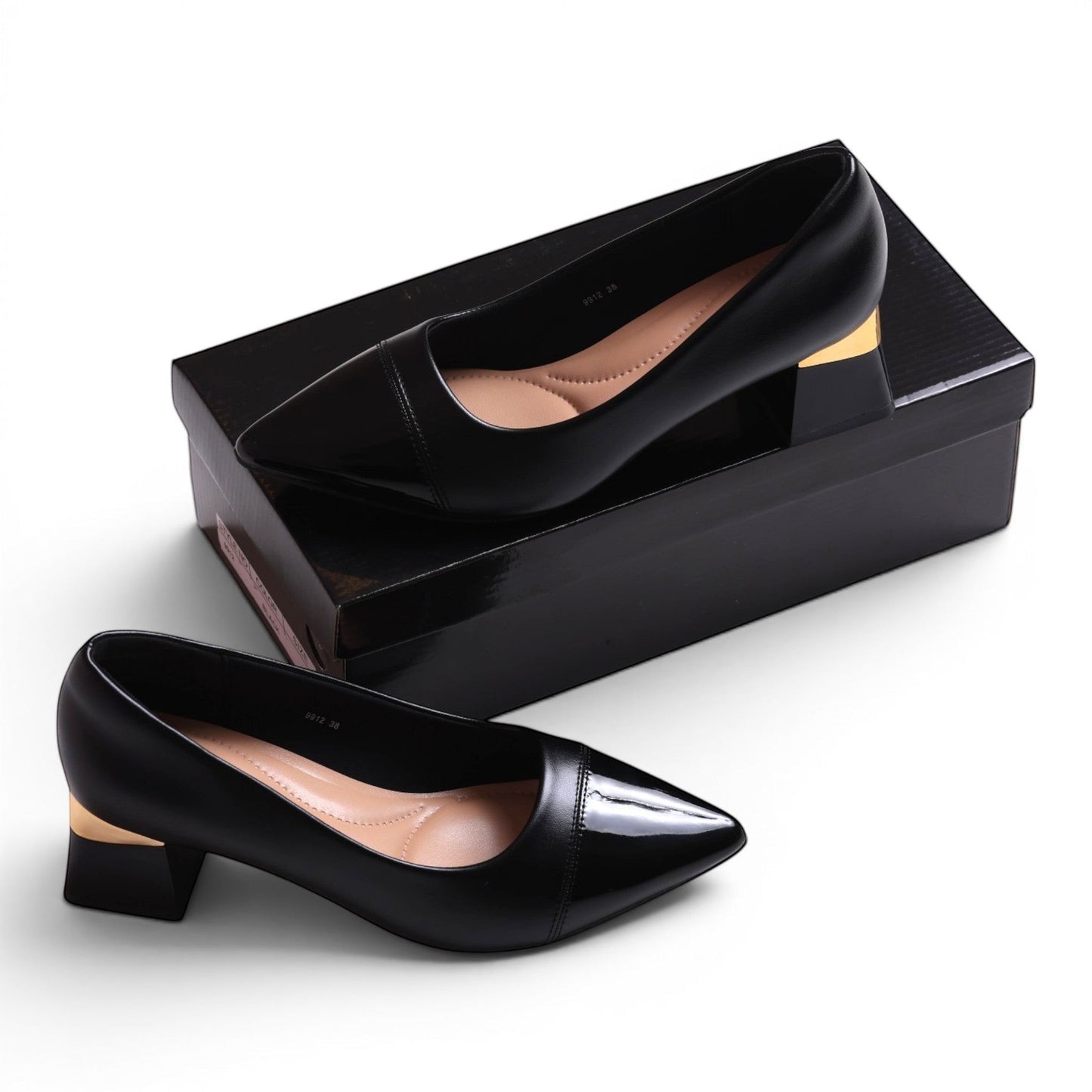 Moda Ug black patent leather pointed toe block heel pumps with gold accent.