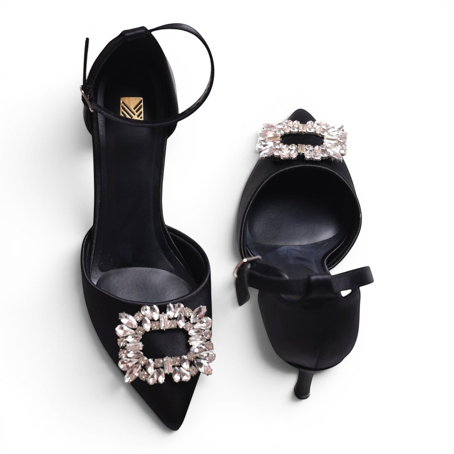 Moda Ug black satin pointed-toe heels with ankle strap and crystal embellishments.
