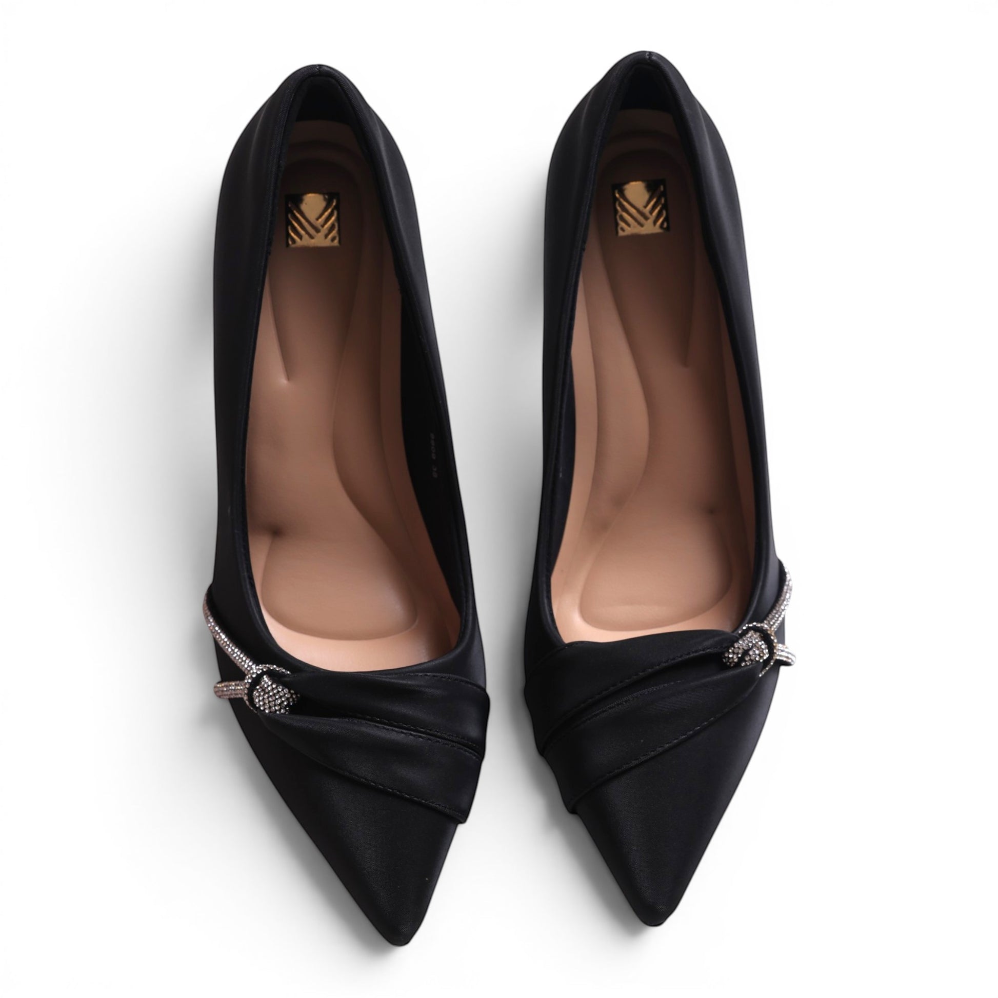 Moda Ug black satin pointed-toe pumps with rhinestone bow detail and low heel.
