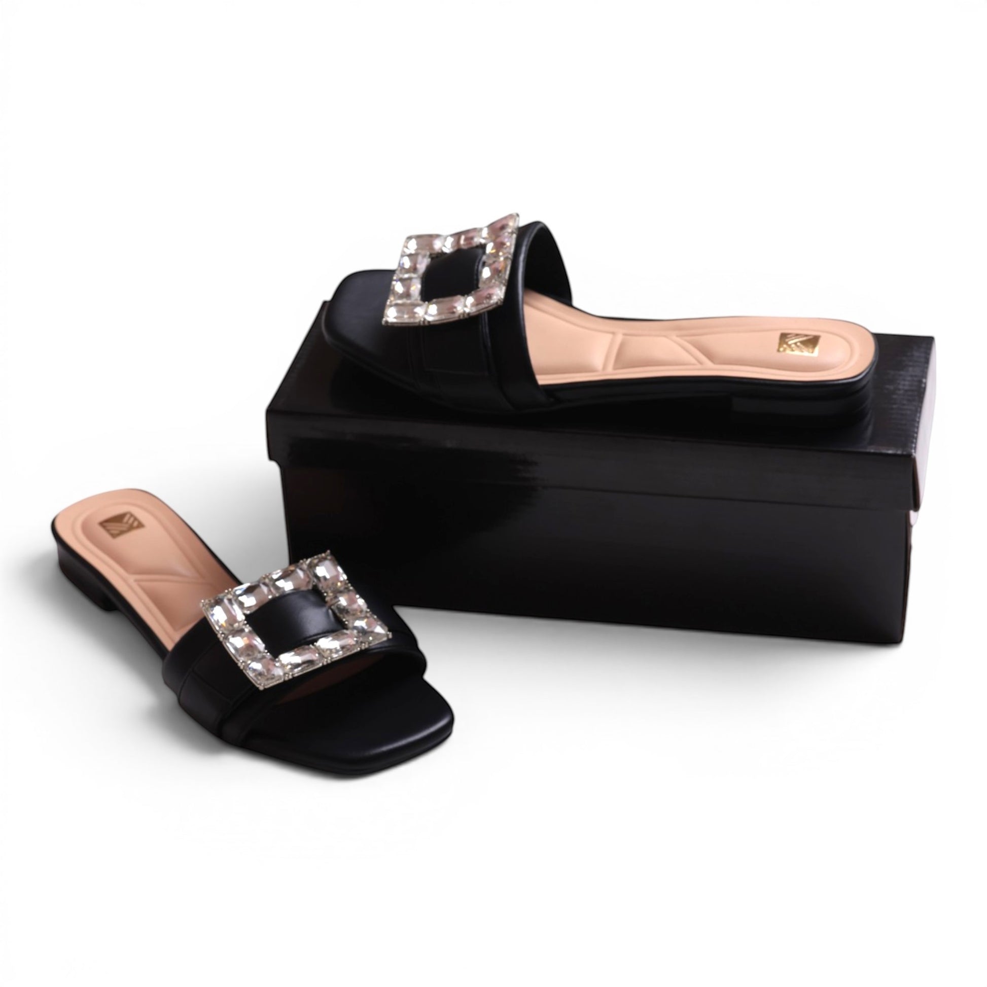 Moda Ug black slide sandals with square crystal embellishment and beige insole.