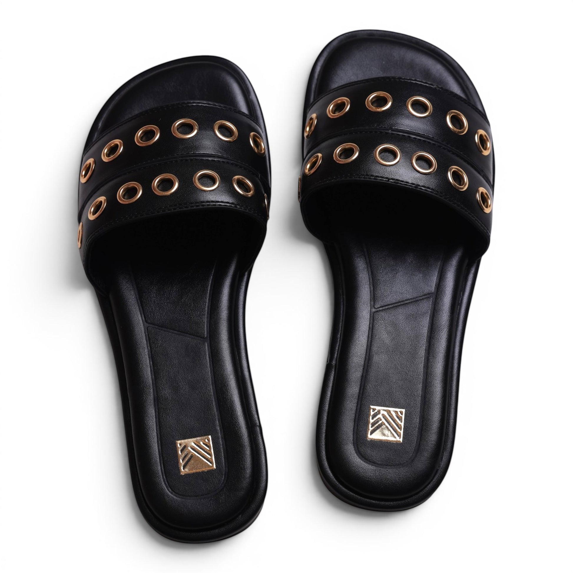 Moda Ug black faux leather slide sandals with gold eyelet details and a square toe.