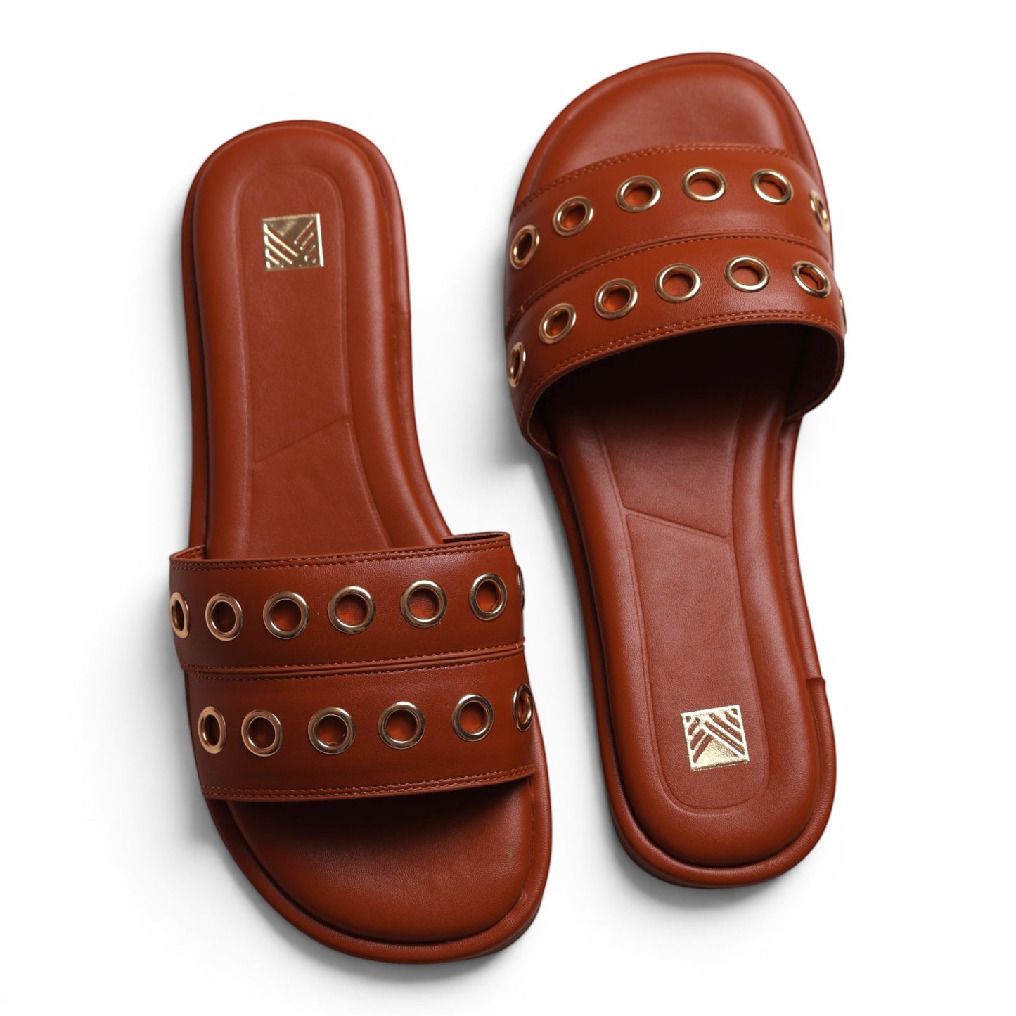 Moda Ug brown leather slide sandals with gold eyelet detail and embossed logo.