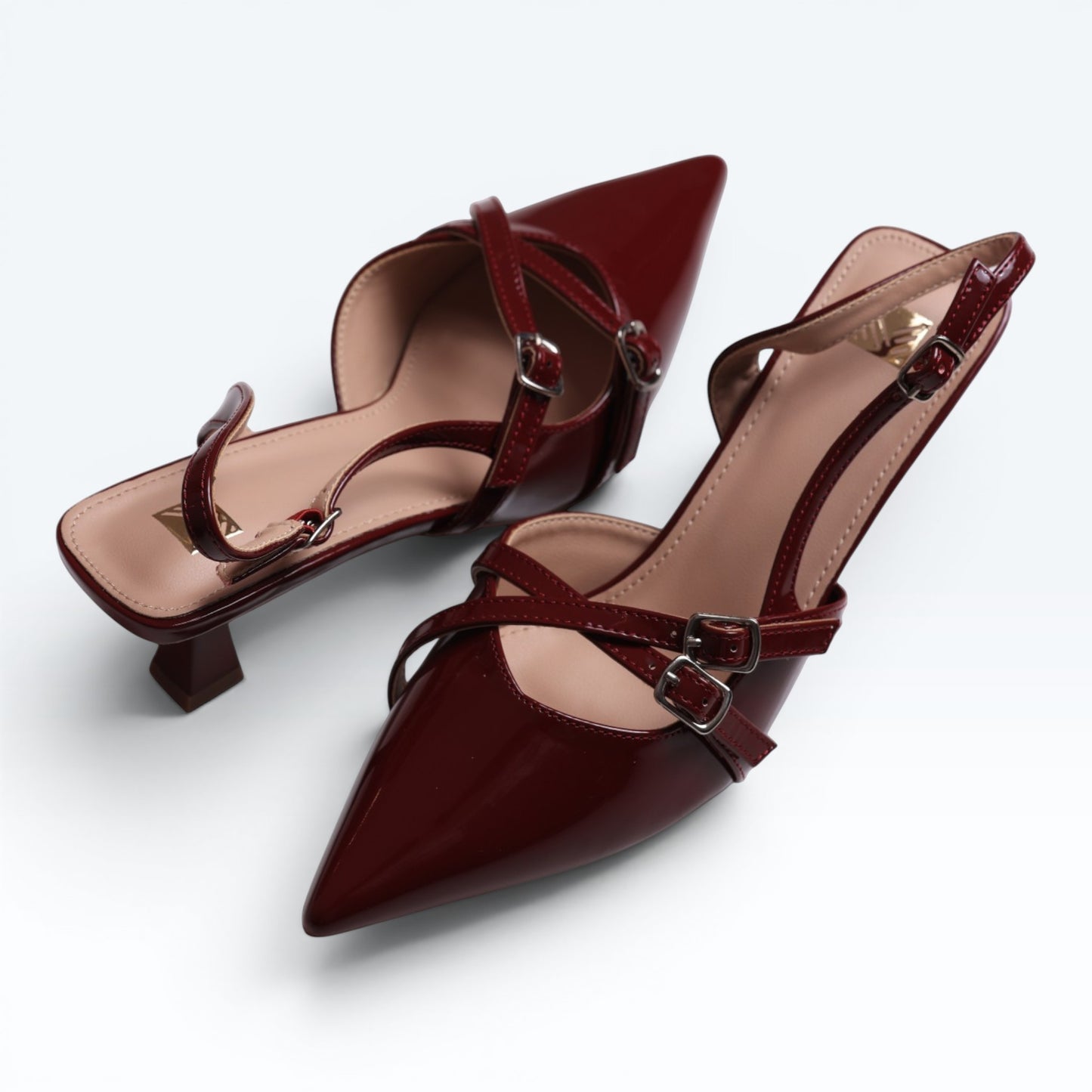 Moda Ug patent wine-red burgundy and black multi-strap slingback heels with pointed toe and silver buckles.