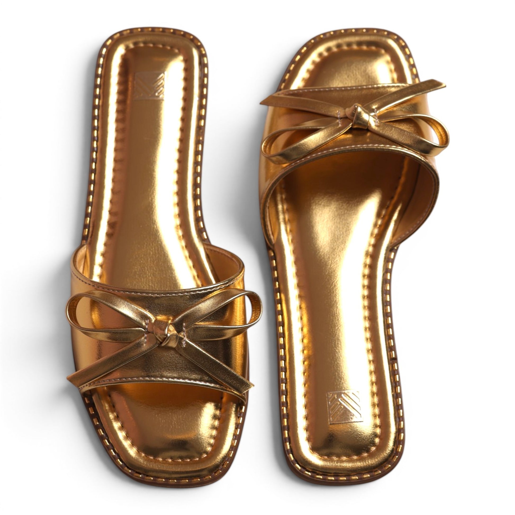 Moda Ug gold metallic slide sandals with bow detail and square toe. Women's slip-on shoes.