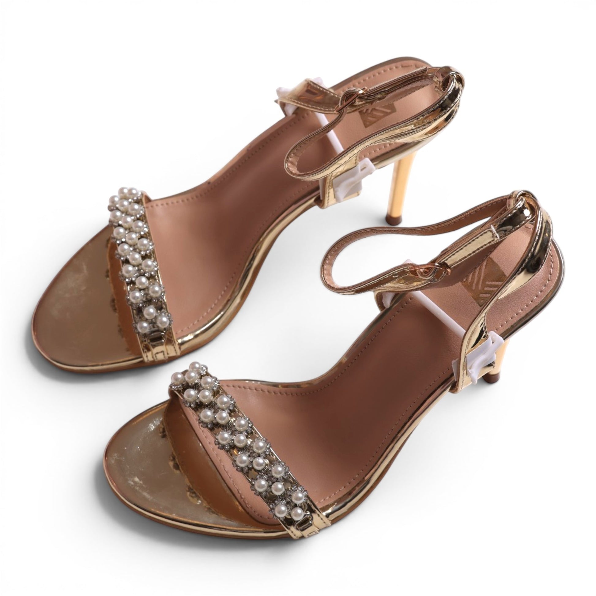 Moda Ug gold metallic heeled sandals with pearl and rhinestone embellished strap and ankle strap.