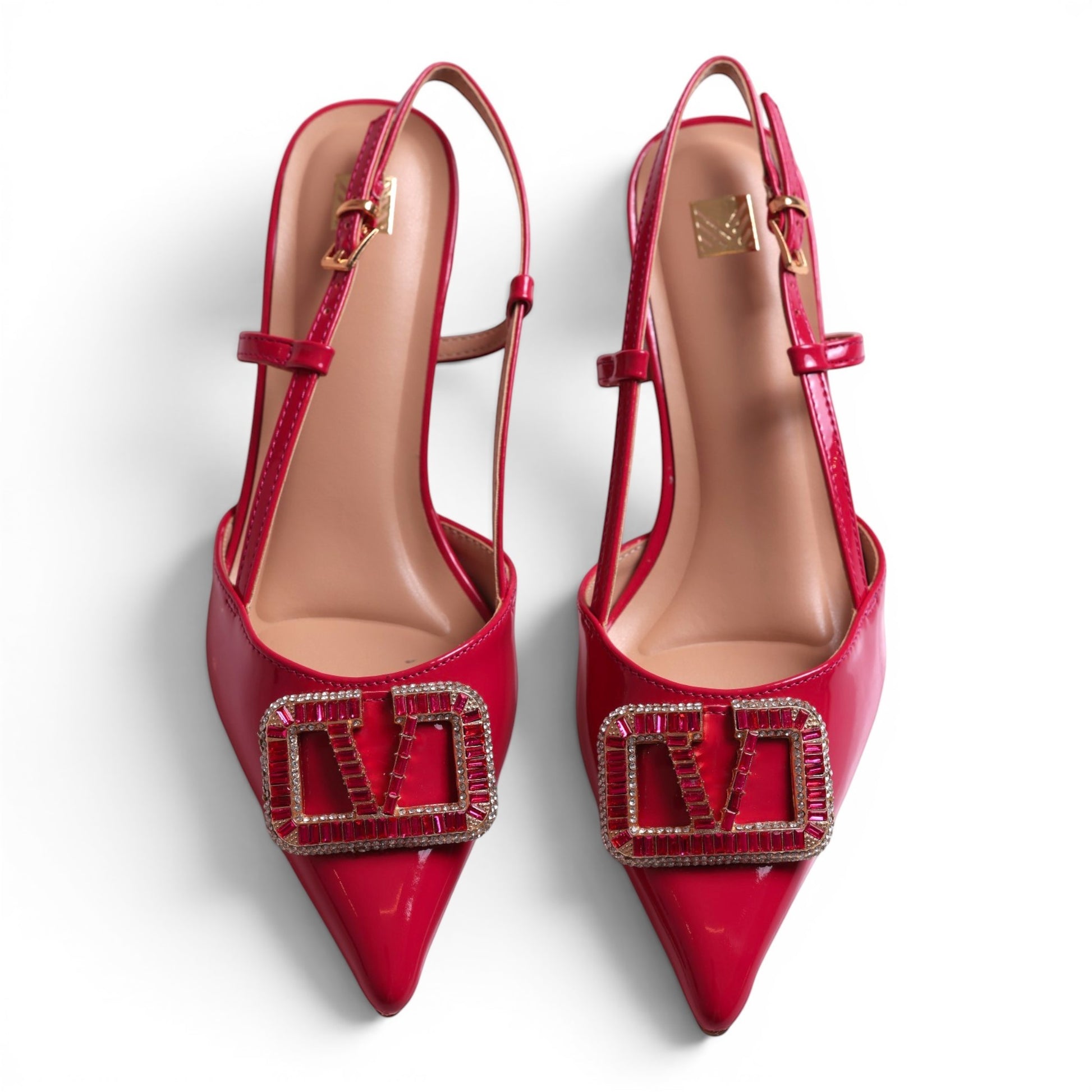 Moda Ug red patent leather slingback heels with crystal embellished logo detail and pointed toe.