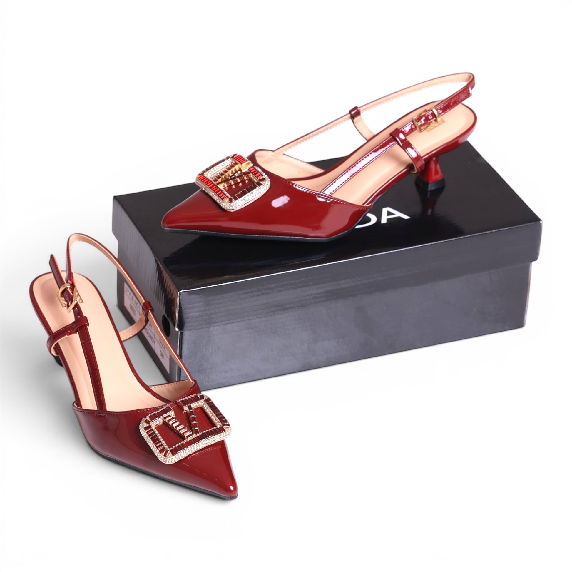 Moda Ug red patent leather slingback heels with pointed toe and jeweled buckle detail.