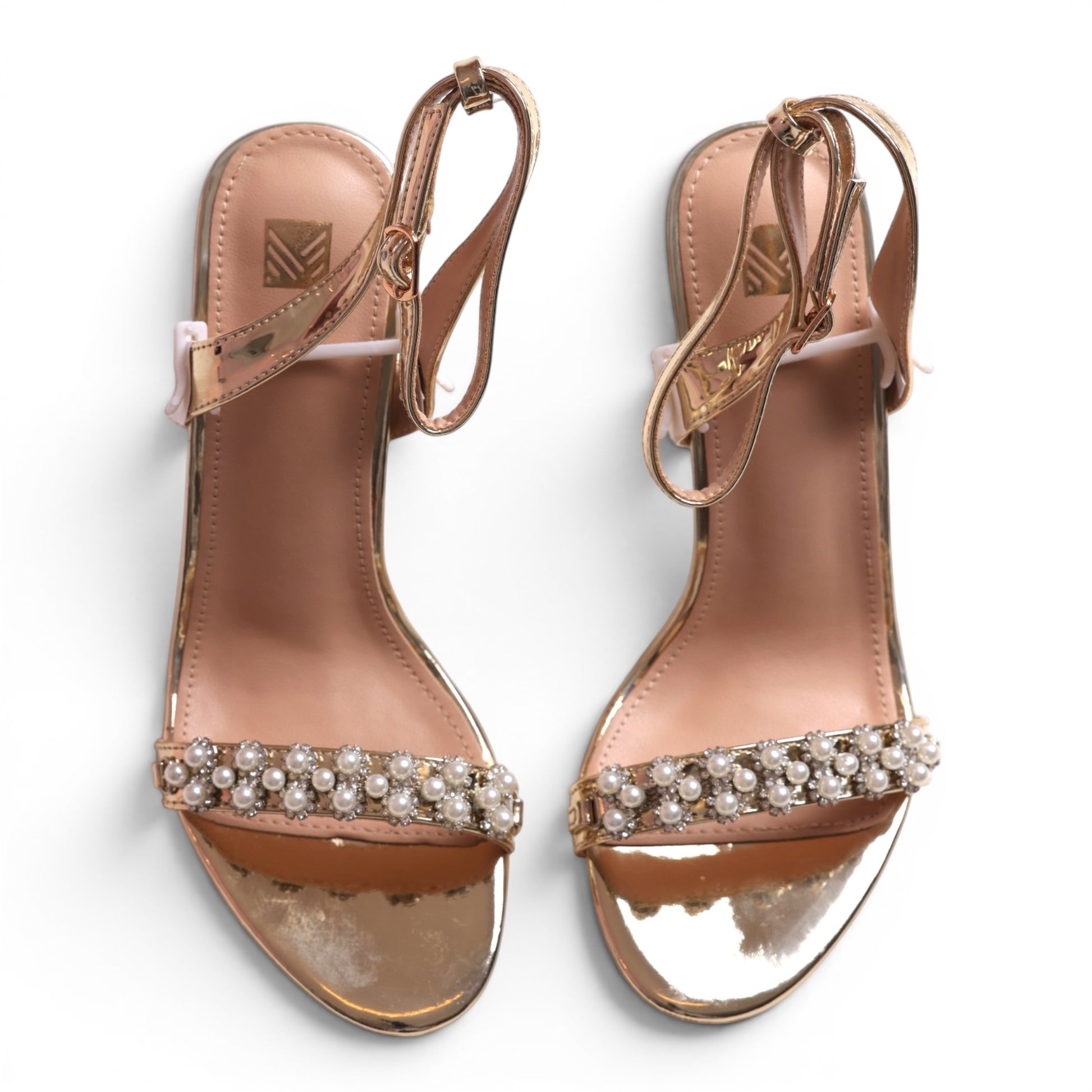 Moda Ug rose gold metallic heeled sandals with pearl and rhinestone embellishments and ankle strap.