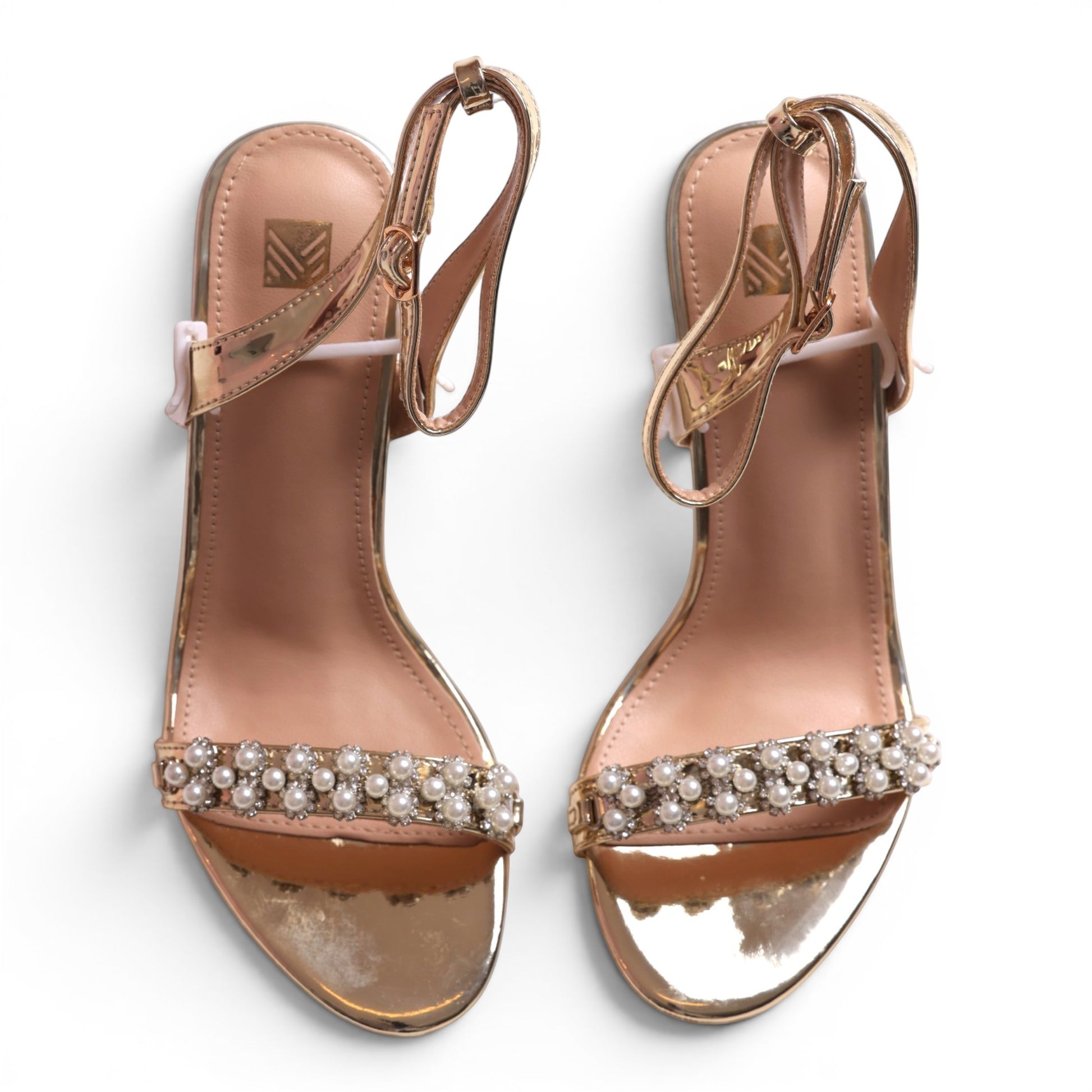 Moda Ug rose gold metallic heeled sandals with pearl and rhinestone embellishments and ankle straps.