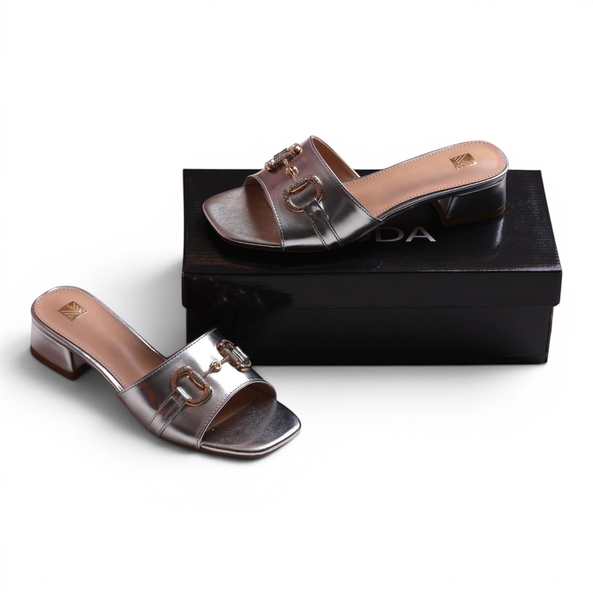 Moda Ug silver metallic slip-on block heel sandals with gold horsebit detail and square toe.