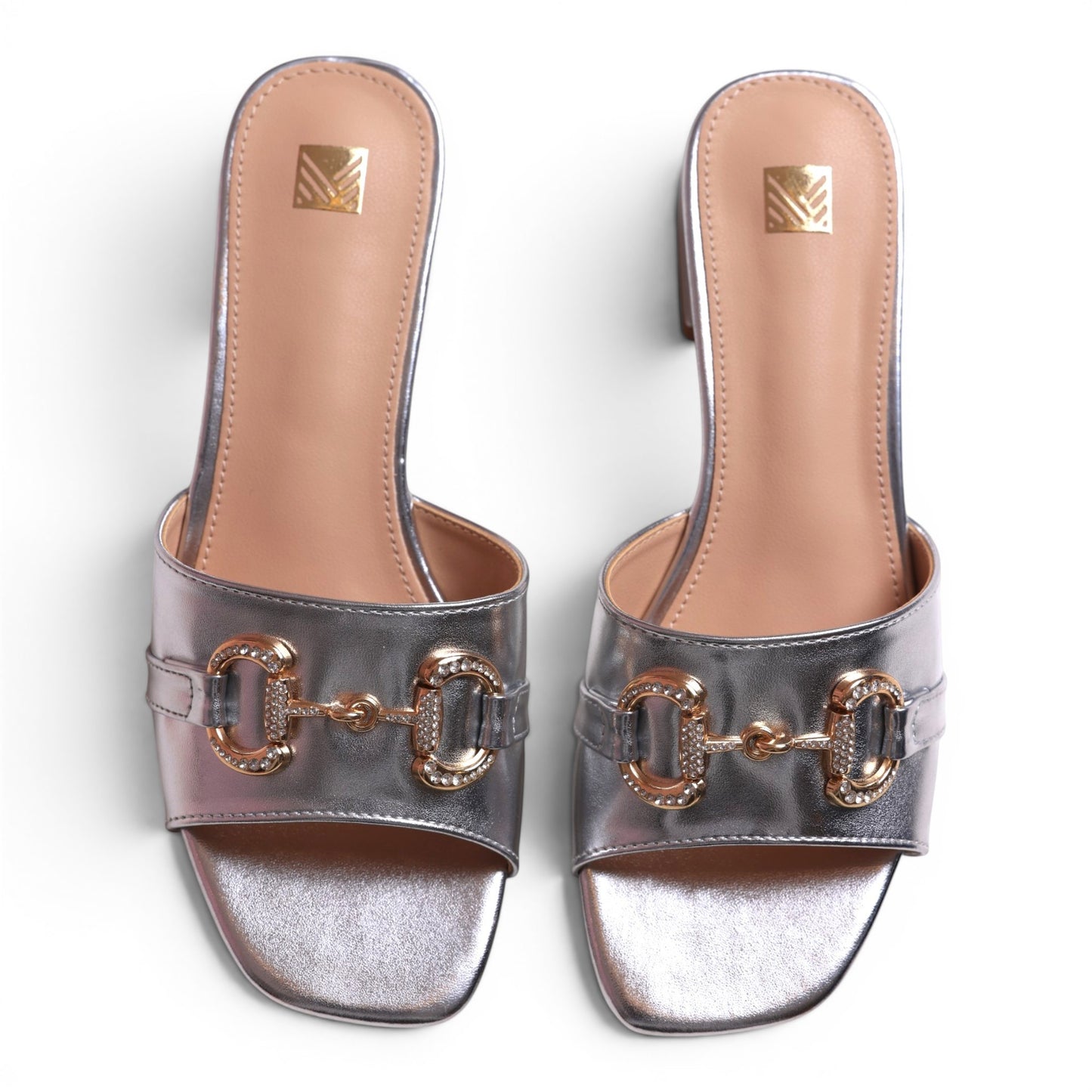 Moda Ug silver metallic slip-on sandals with gold horsebit detail and crystal embellishments.