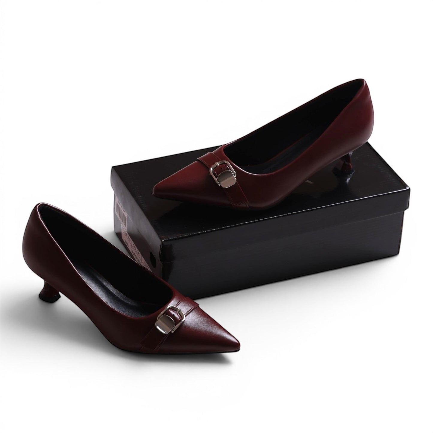 Moda Ugo burgundy leather pointed-toe kitten heel pumps with silver buckle detail.